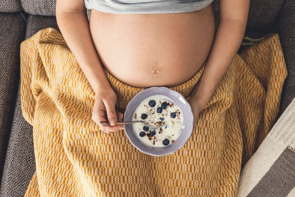 a pregnant woman eating a healthy breakfast