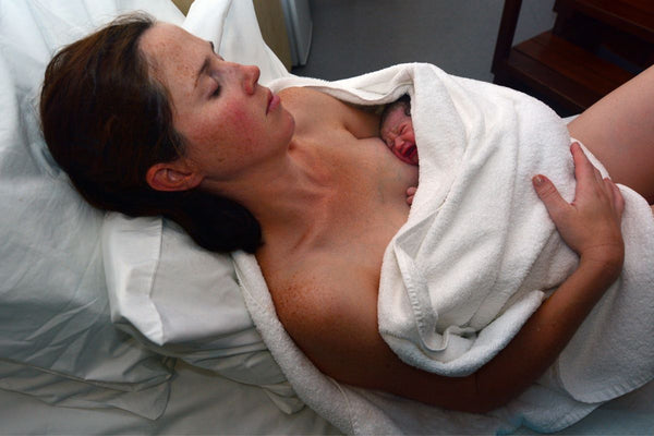 A mother embracing her precious newborn baby in her arms after a C-section