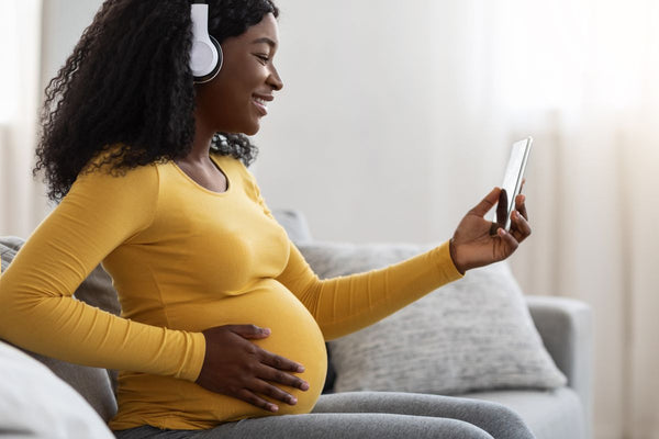 a pregnant woman is using her phone to access remote maternal support