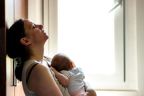 Tired and concerned mother holding her baby