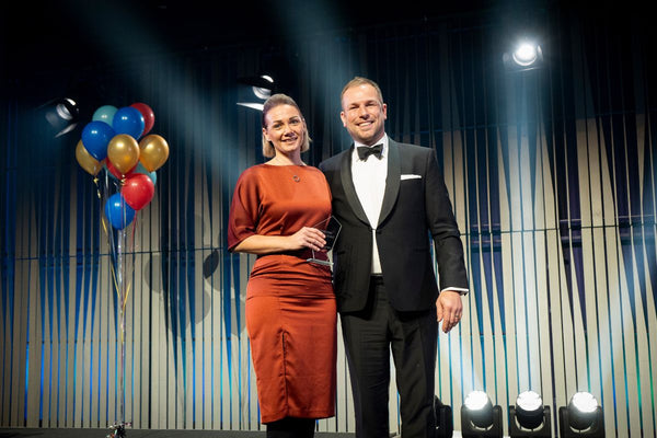 Lola&Lykke's CEO Laura holding an award on stage with the host