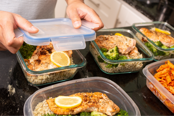 Meal prep containers of salmon, rice, and broccoli
