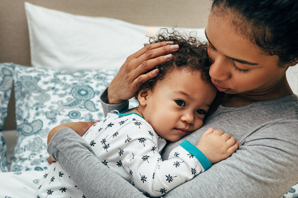 Mother holding her toddler in her arms to give comfort and support