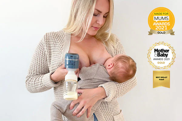 Äiti käyttää Lola&Lykken sähkökäyttöistä rintapumppua ja imettää vauvaansa samanaikaisesti