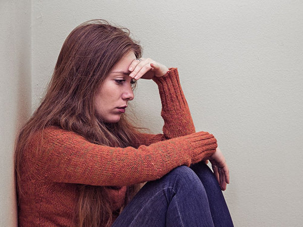 Nainen punaisessa neuleessa tuntee surua imettämisen yleisimmistä haasteita