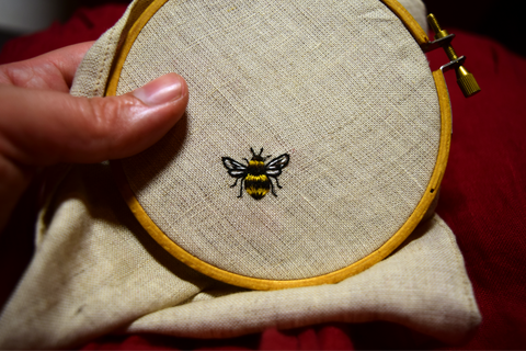 Tiny bee hand embroidered on oatmeal linen in yellow and black