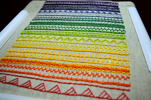 Embroidery band sampler almost complete in bright rainbow colors