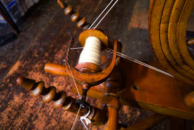 Spinning wheel with fine white yarn being spun