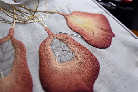 Three iris petals; one finished and two nearing completion. All in shades of rust and peach.