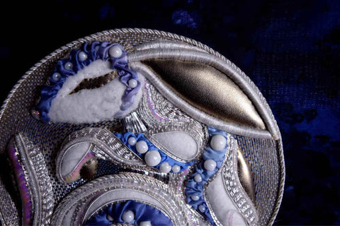 Closeup of Moon Rabbit worked in silver on blue silk; body of rabbit is nearly covered with embroidery but face still has large empty areas.