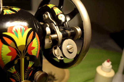 Closeup view of a Singer 66 sewing machine (1924) showing lotus decals, flywheel, and bobbin winder. Decals are freshly applied and machine is clean and shiny.