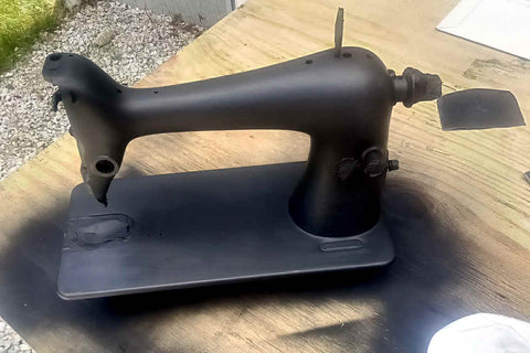 Singer 66 sewing machine body, stripped of hardware and painted with satin black primer on board