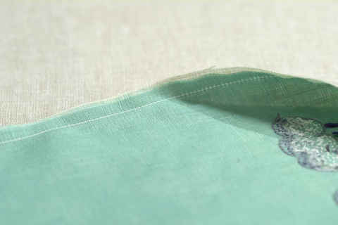 Green and cream colored linen sewn right sides together with half inch seam allowance