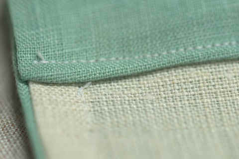 Inside of bag showing folded over casing (green) and line of stitching up the side that stops just before it