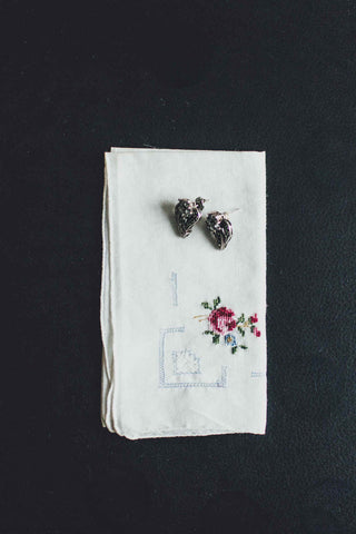 Ladies handkerchief with drawnwork and rose design, a pair of earrings laying on top