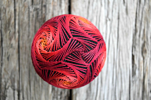 Glowing Embers temari ball with red and yellow pattern on black