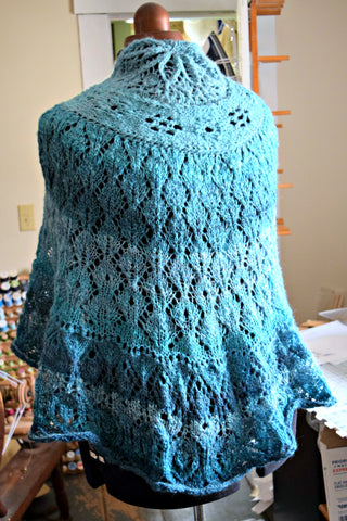 Circular shawl made from teal handspun in a lacy knit pattern