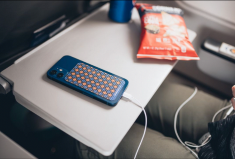 CatTongue Grips on cell phone sits on airplane table tray. 