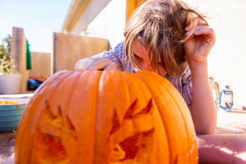 A child carves into a jack-’o-lantern.