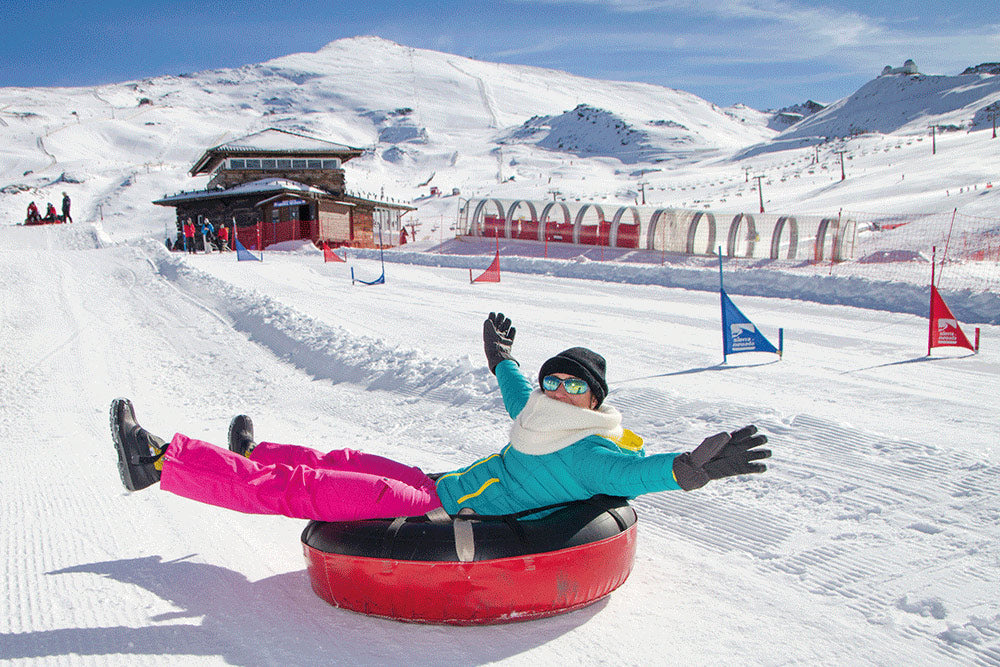 Snow tubing, mujer deslizándose en la nieve sobre un neumatico