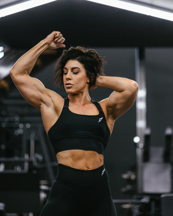 Dana bailey posing in a gym.