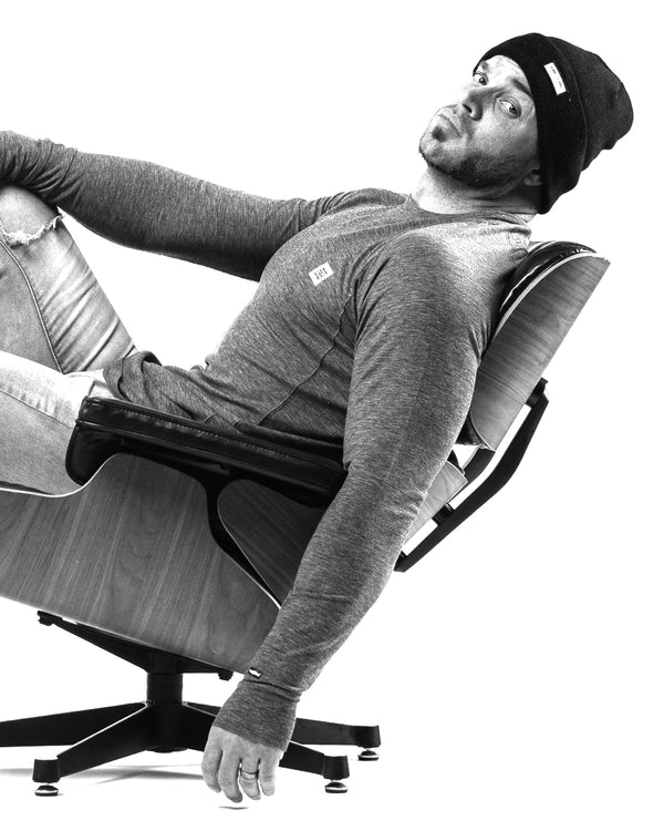 Monochrome image of Rob Bailey leaning back in office chair in front of a white background.
