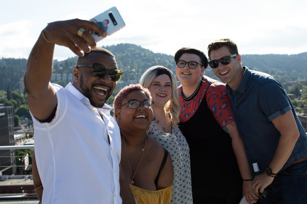 Five friends taking photograph and smiling