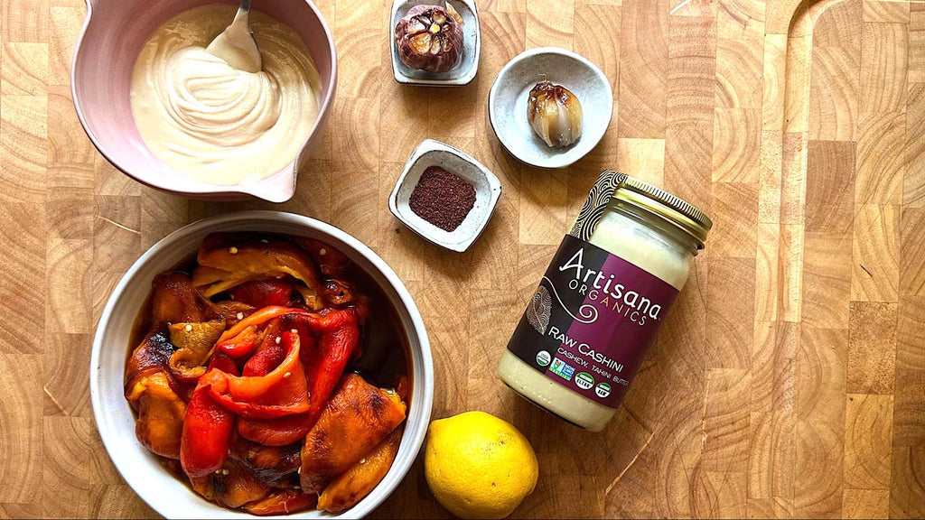 A jar of Artisana Cashini with ingredients prepped to make red pepper sauce