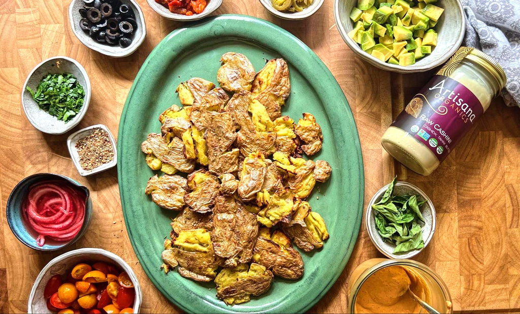 Smashed potatoes on a green plate, other ingredients surround it for assembling the recipe.