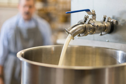 Hand Cream flowing from a warming tank into a filling hopper.