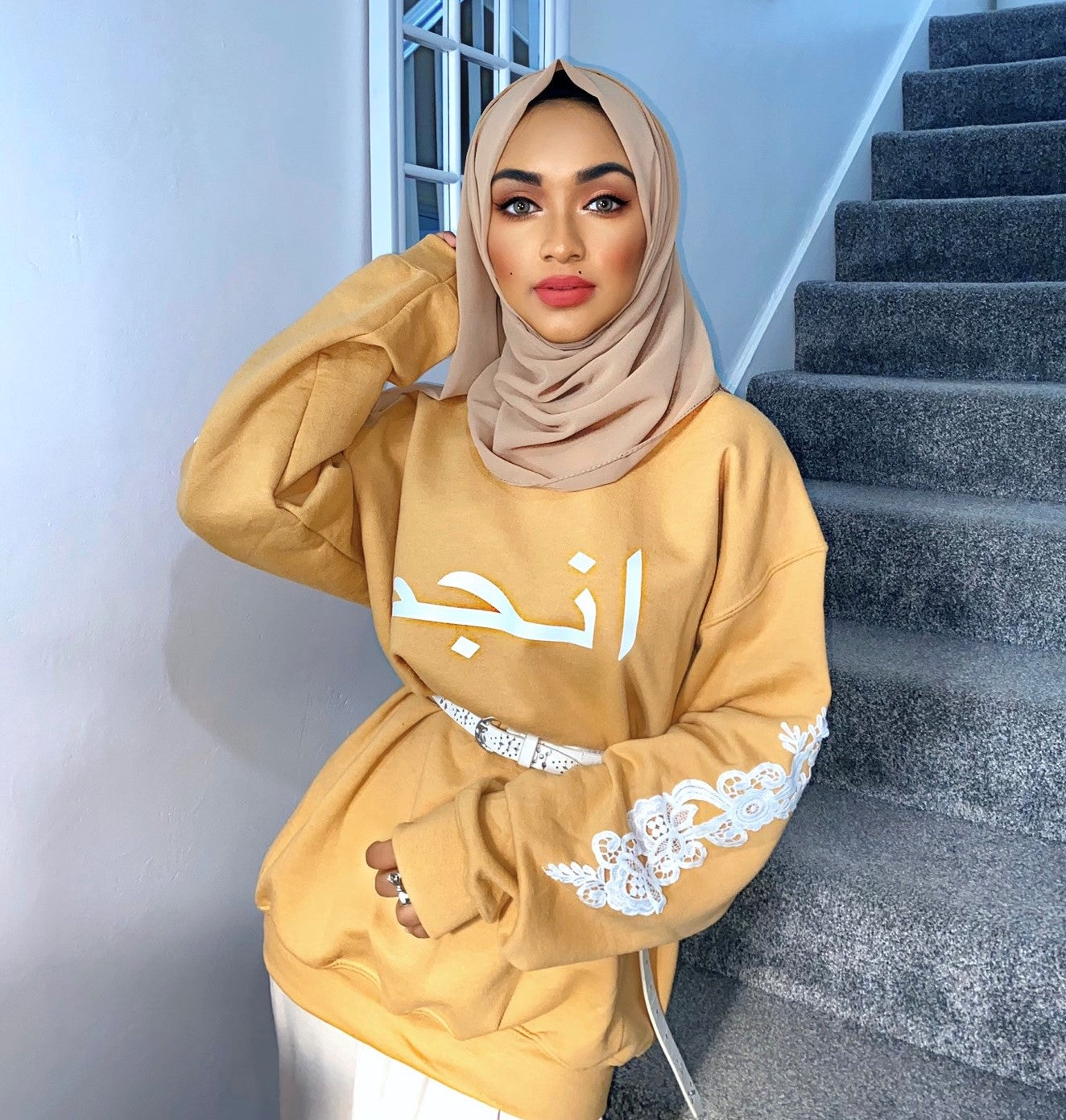 gold personalised hoodie with white arabic name and white floral sleeve embroidery