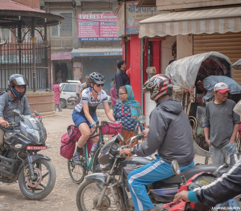 Jennifer Gurecki biking through traffic in Nepal.