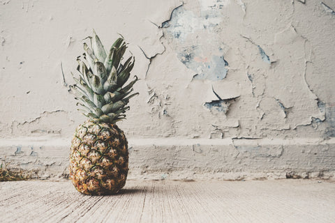 Pineapple with peeling wallpaper in the background