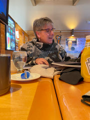 Jane Ryan reviews her custom book at a table in a restaurant