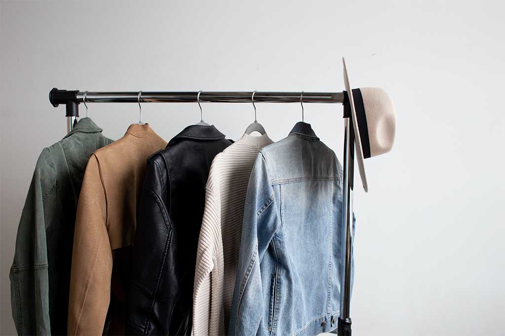 Capsule Wardrobe on clothing rack. Minimalist clothing in monochromatic colors.