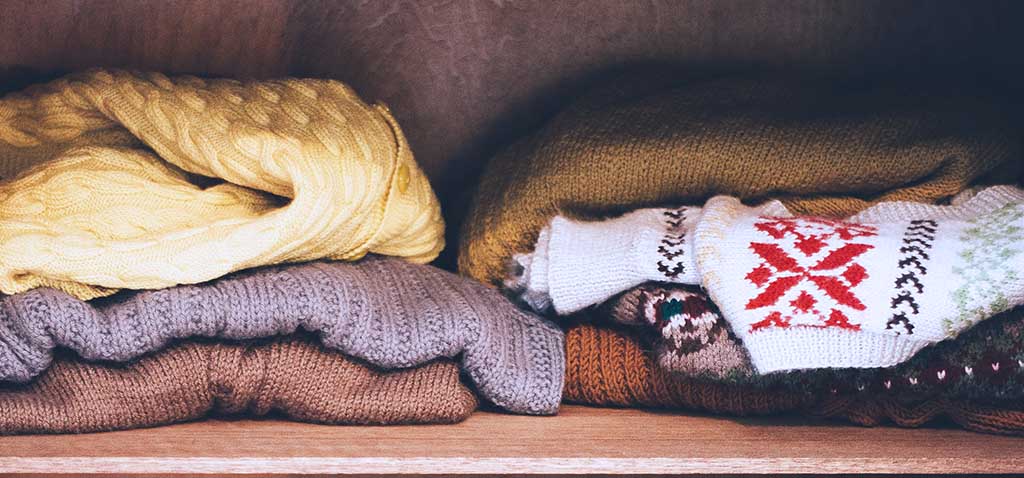 Closet clean out before picture showing messy sweaters badly folded