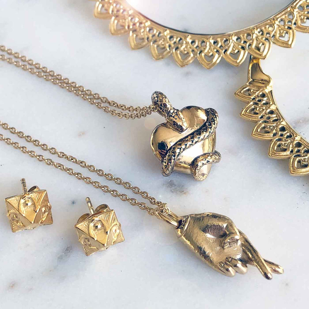 sustainable fashion jewelry, gold charm necklaces, gold hoop earrings, and gold pyramid studs