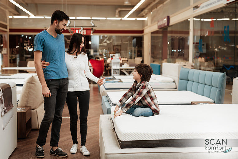 Happy family with son sitting on mattress