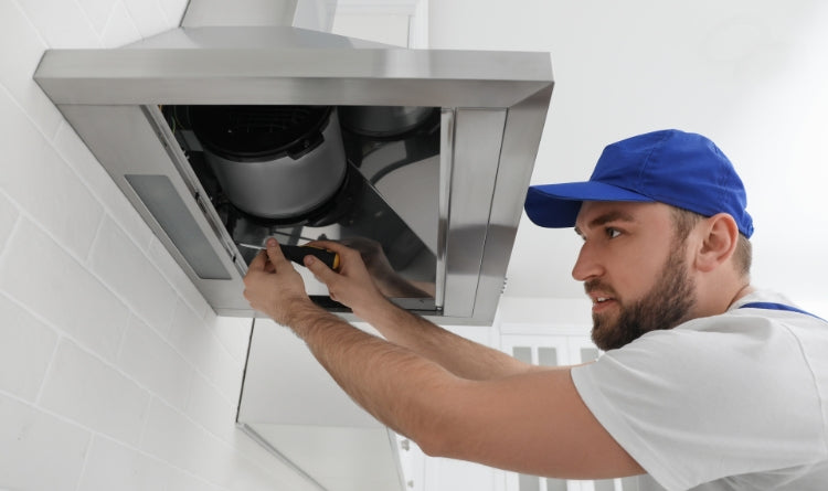 Solving Noisy Range Hood Cap Problems in Windy Conditions image showing a professional working on a range hood