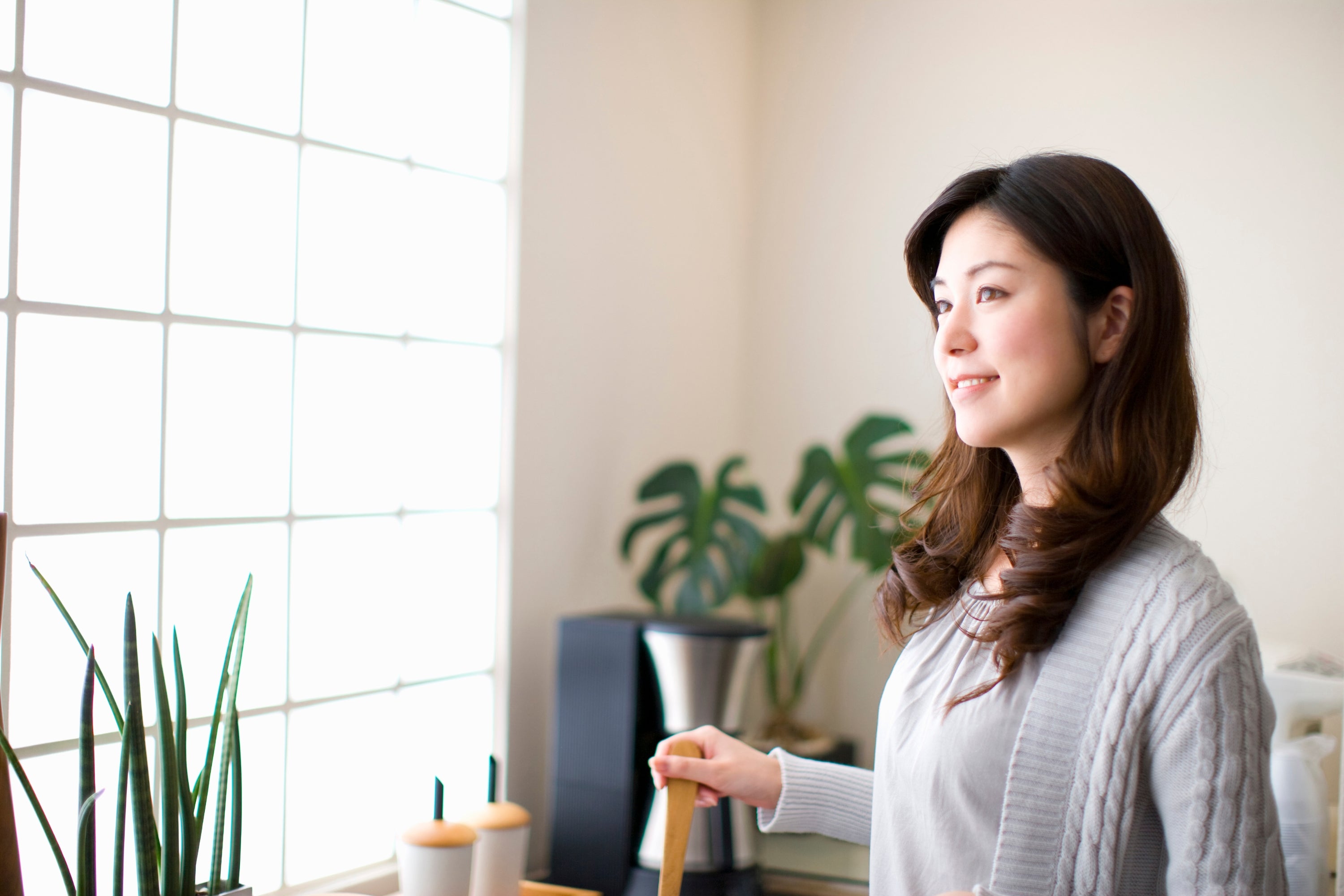 Must Know Facts About Your Indoor Air Quality woman cooking in the kitchen looking out the window