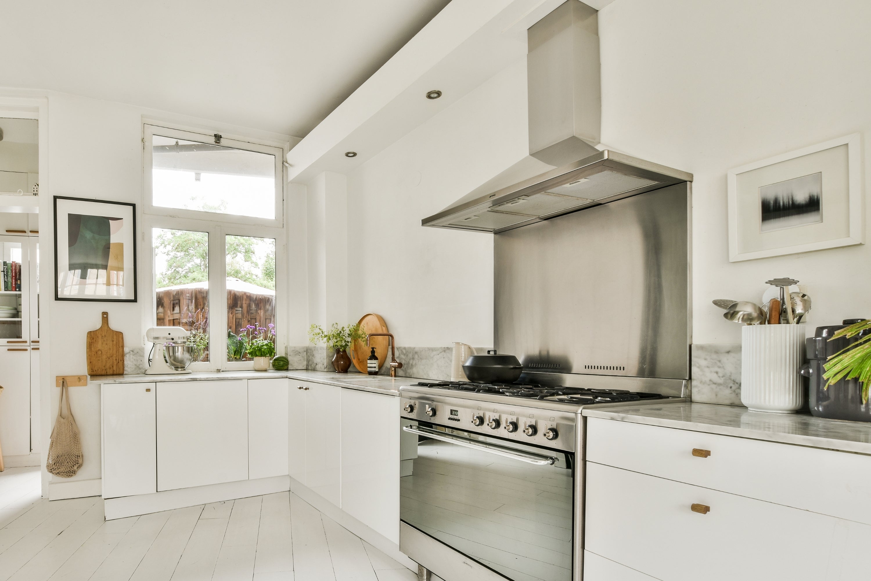 5 Ways to Clean Stainless Steel with Ingredients You Already Have at Home image showing stainless steel range hood, backsplash, and oven