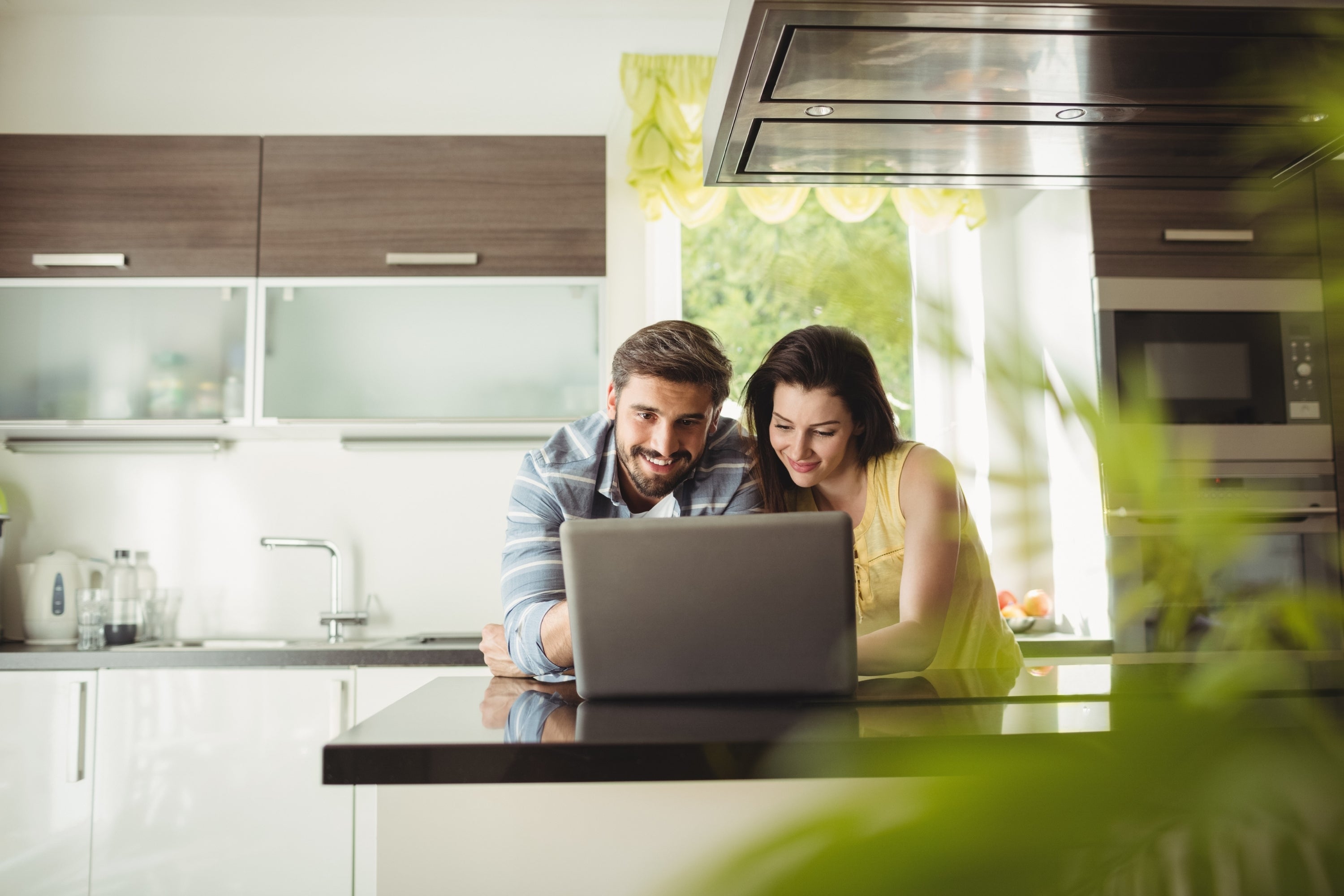 Couple browsing online for a kitchen range hood company to purchase from