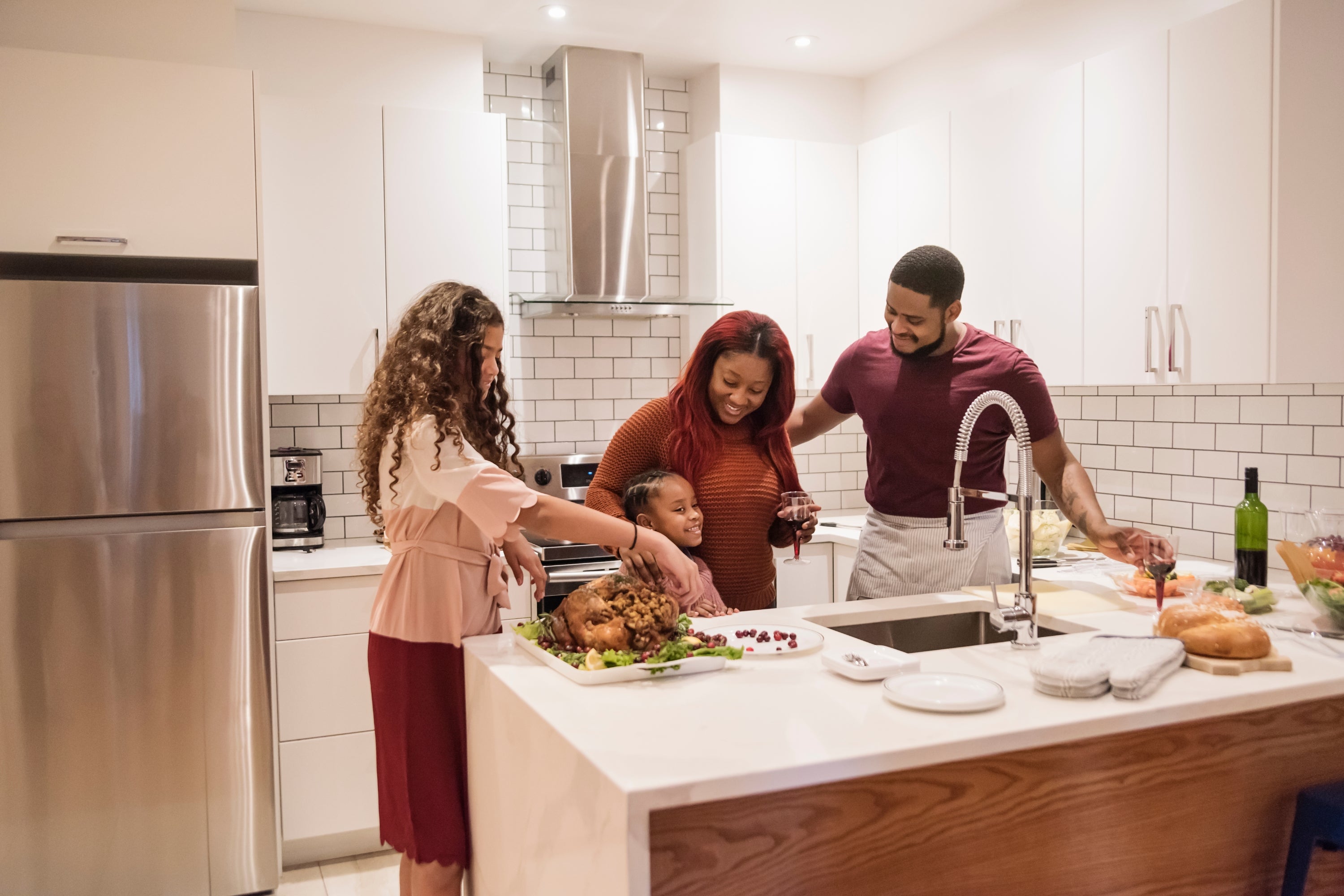 What is the Difference Between Product Warranty and Product Protection Plans? photo showing a family cooking in the kitchen with their range hood