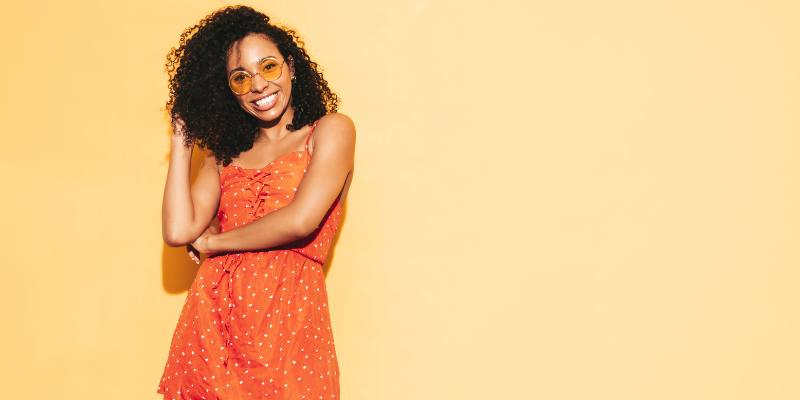 Curly hair model in a summer dress with honey colored glasses