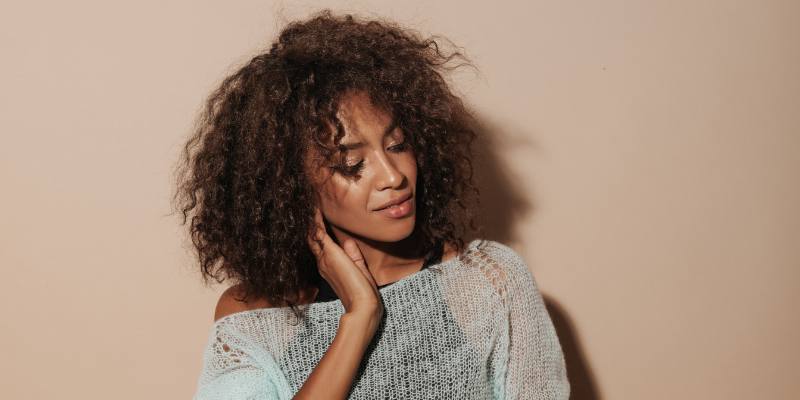 Brown curly hair female model wearing a transparent top