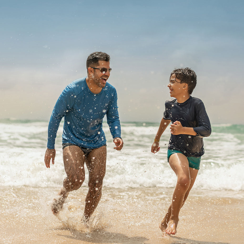 Man and boy running on the beach