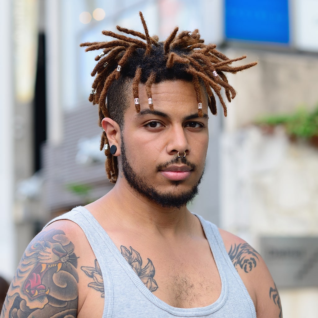 Man With Tattoos Showing His Dreadlocks Style