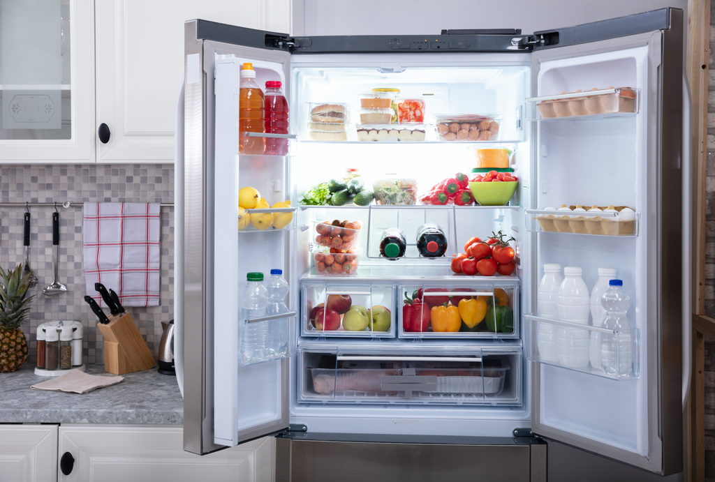 An open fridge stocked with fresh fruits and veggies