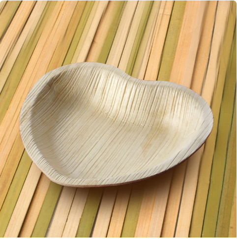 A heart-shaped palm leaf plate, featuring natural textures and patterns, ideal for eco-friendly dining and sustainable living.