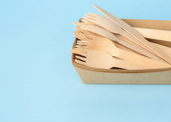 Composting disposable birchwood cutlery for eco-friendly waste disposal.